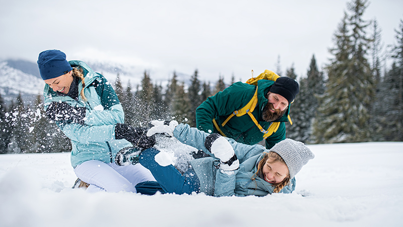 Family with small daughter having fun outdoors in winter nature, Tatra mountains in Slovakia.